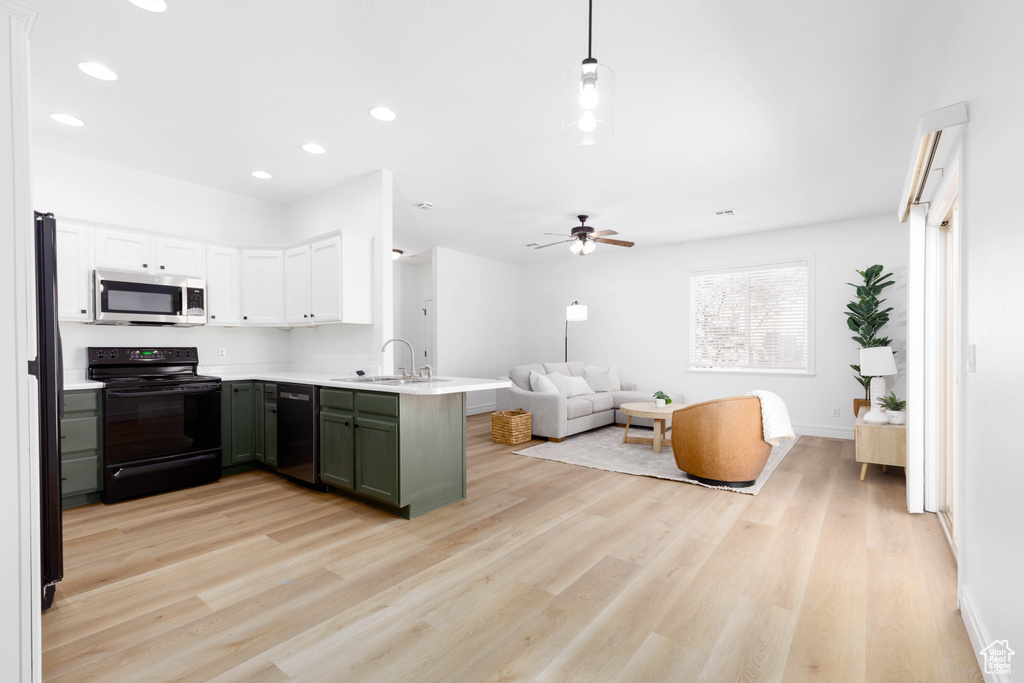 Kitchen with a peninsula, light wood-style floors, open floor plan, recessed lighting, and black appliances