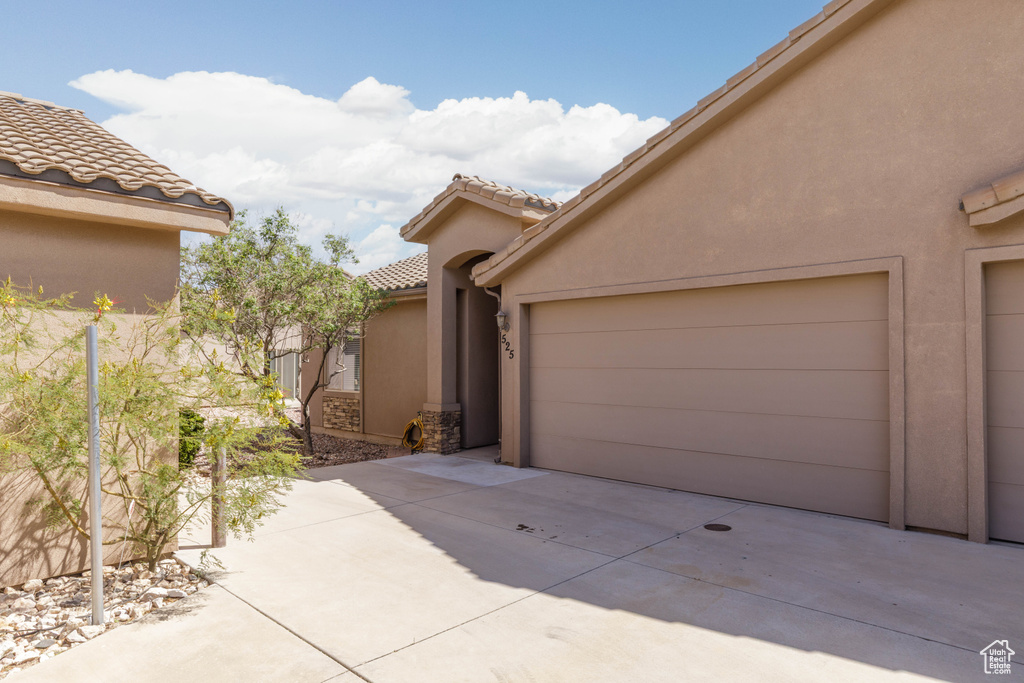View of side of property featuring stucco siding and a tiled roof