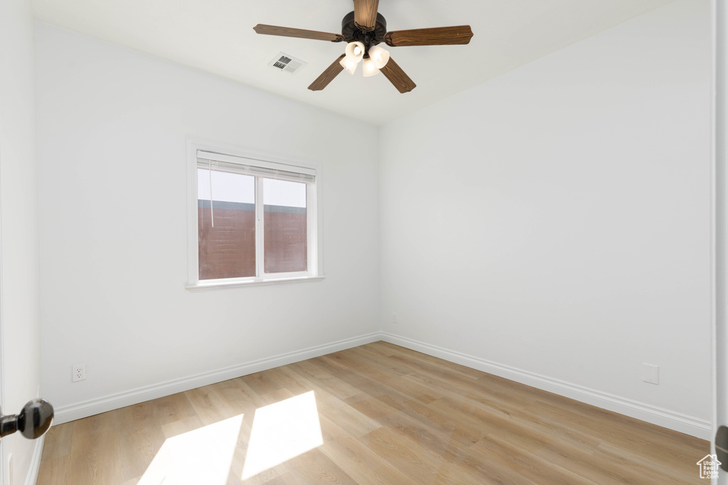 Empty room featuring baseboards, ceiling fan, and light wood-style flooring