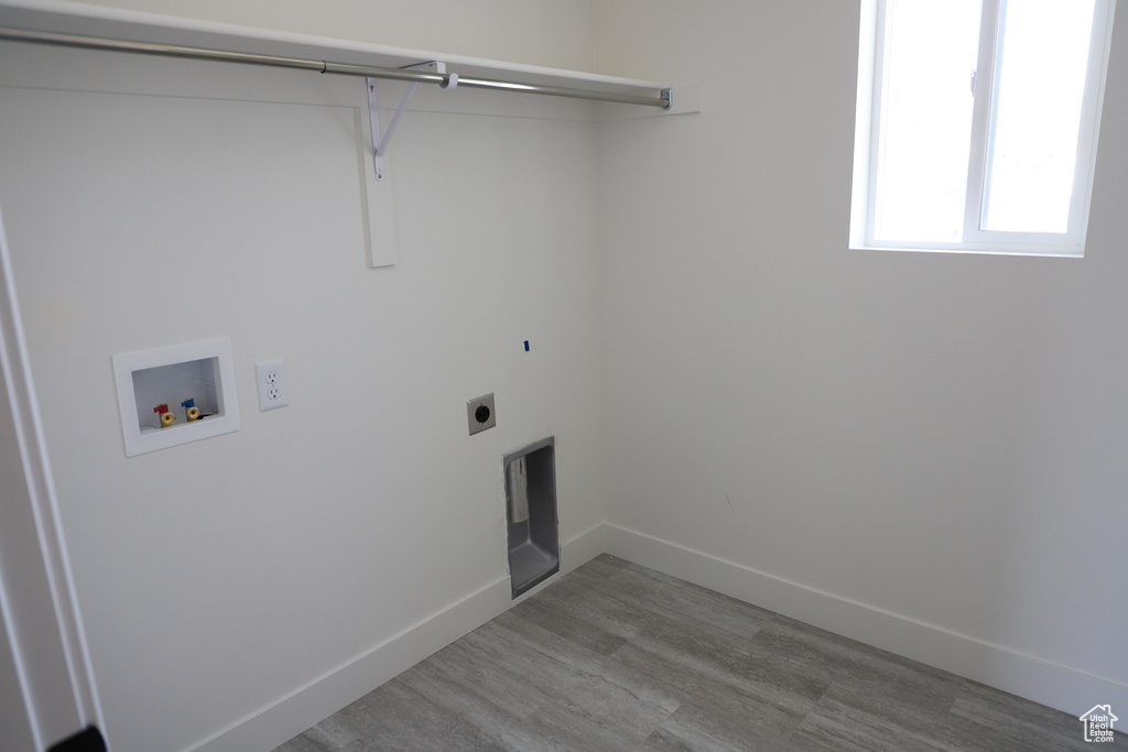 Laundry area featuring laundry area, washer hookup, baseboards, wood finished floors, and hookup for an electric dryer