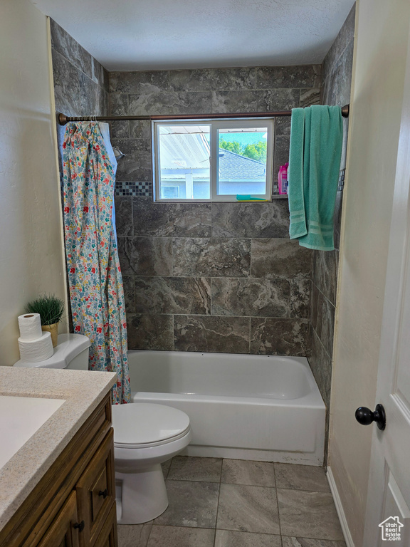 Full bath with vanity, shower / bath combo, and toilet