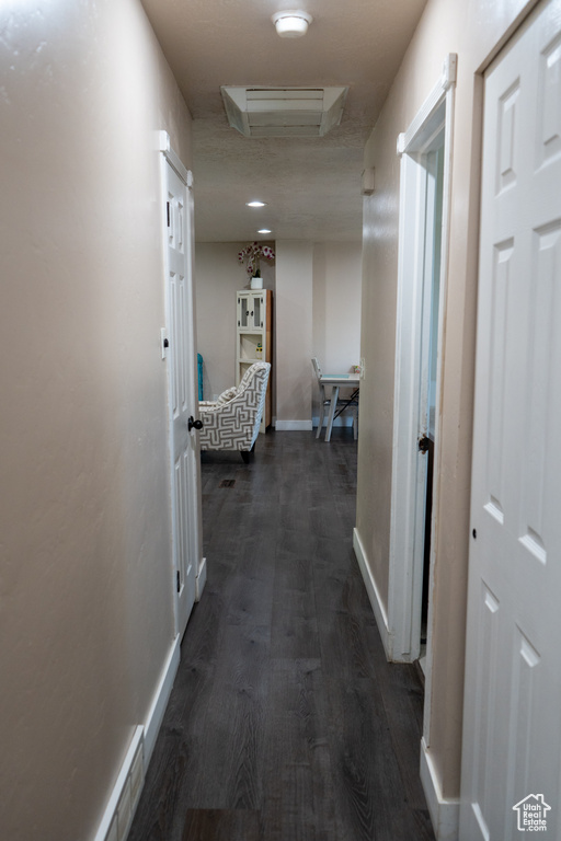 Hallway featuring baseboards and dark wood-type flooring
