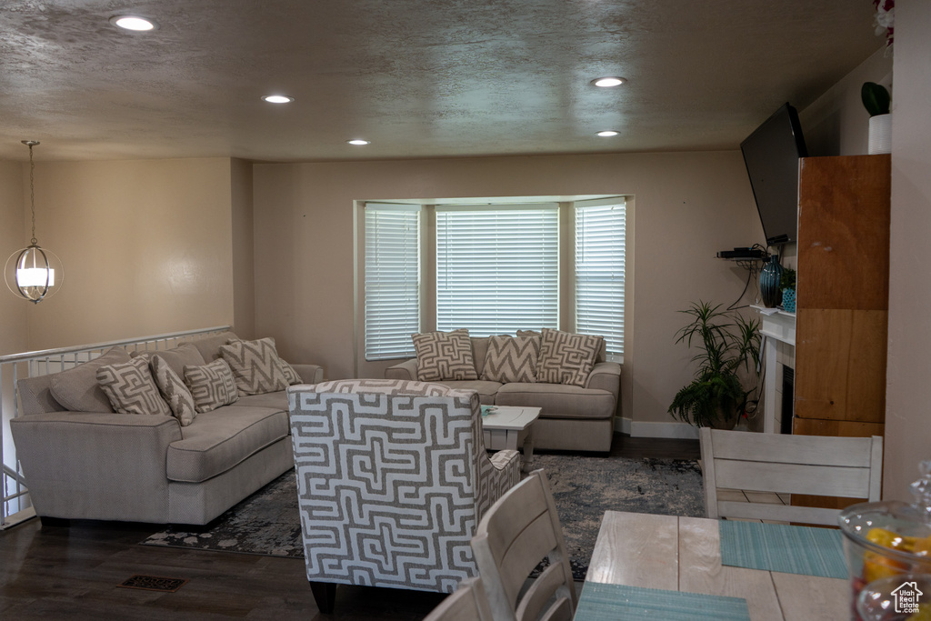 Living area featuring recessed lighting, a textured ceiling, wood finished floors, and a fireplace