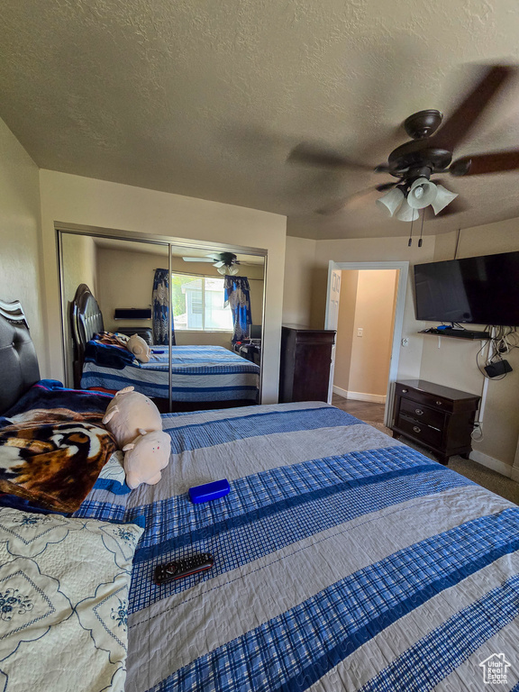 Bedroom featuring a closet, a textured ceiling, ceiling fan, and baseboards