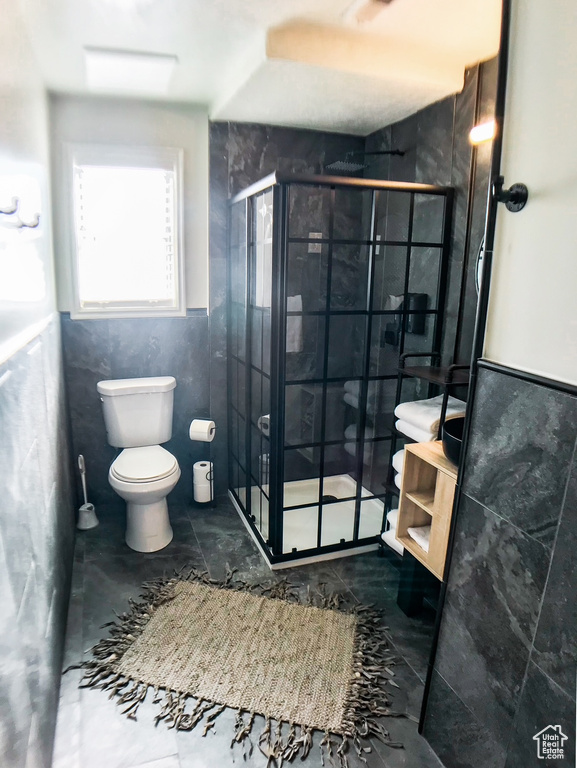 Full bathroom featuring a stall shower and toilet