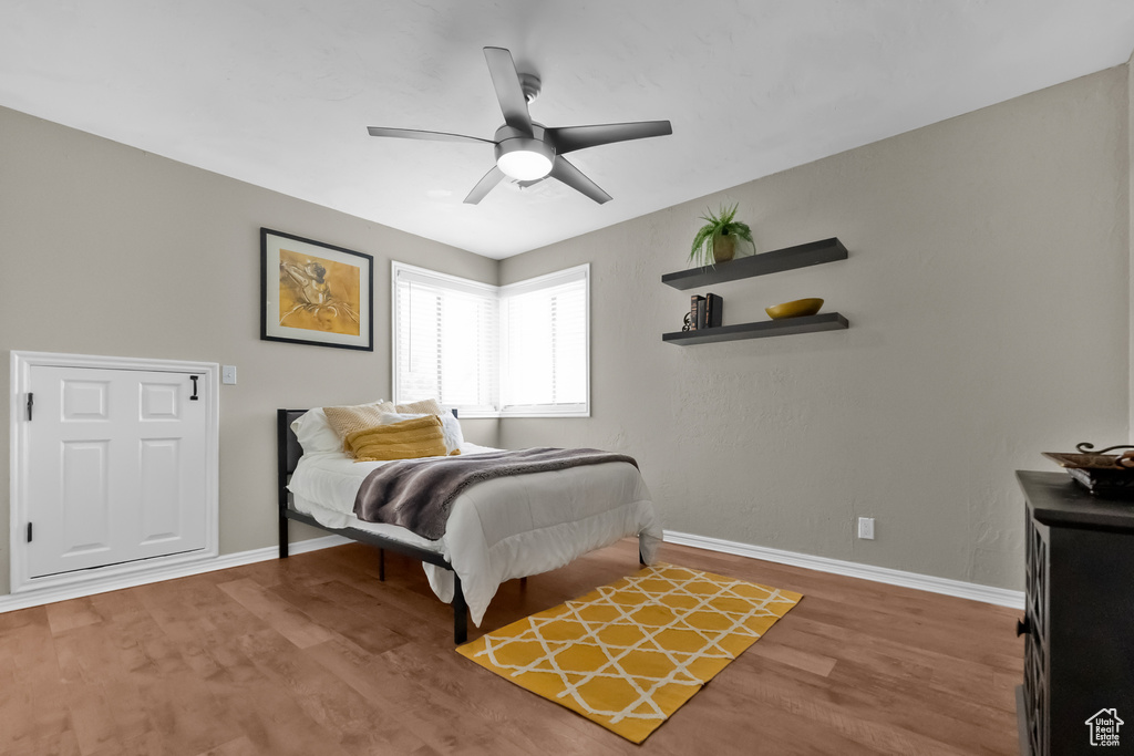 Bedroom featuring baseboards, ceiling fan, and wood finished floors
