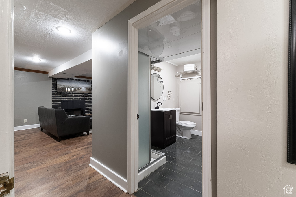 Hall featuring a sink, baseboards, and a textured ceiling