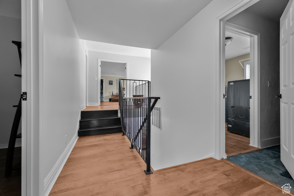 Staircase with visible vents, baseboards, and wood finished floors