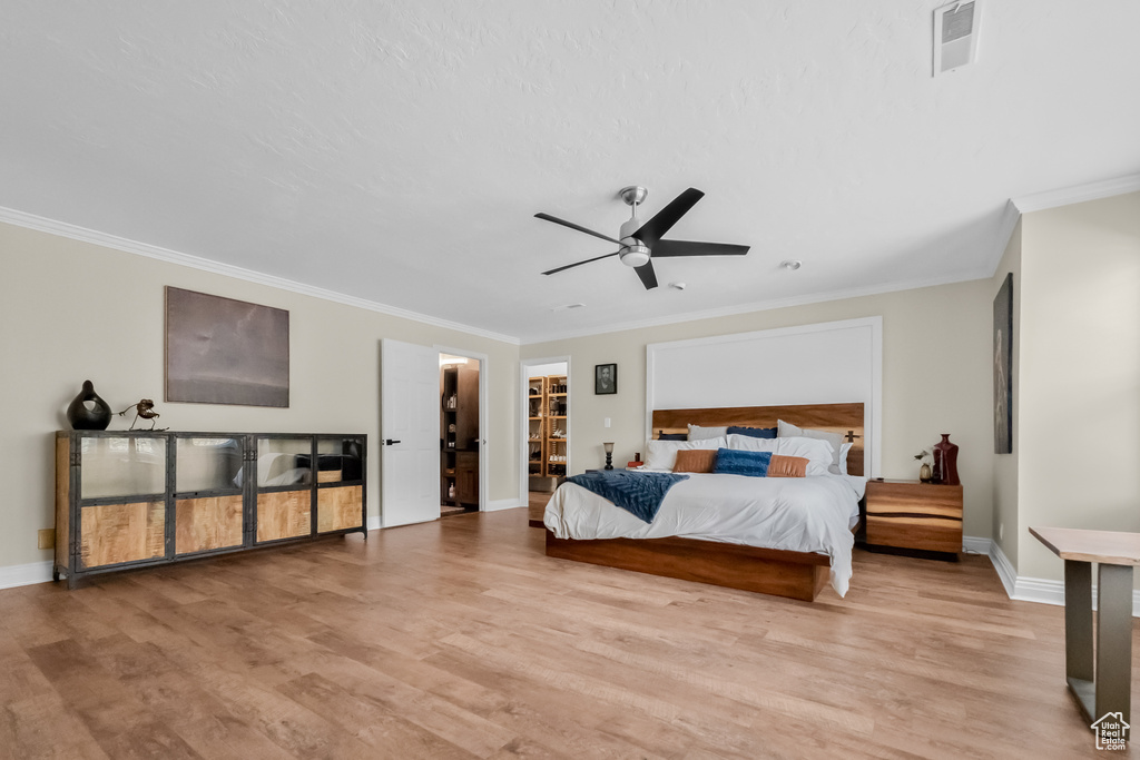 Bedroom with visible vents, ornamental molding, baseboards, and light wood-style flooring