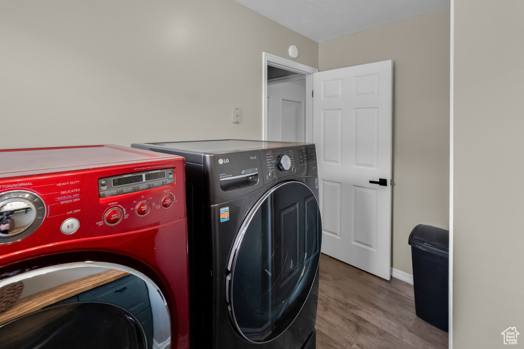 Washroom with laundry area, baseboards, wood finished floors, and washer and dryer