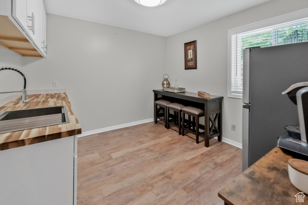 Interior space with baseboards, a sink, and light wood-type flooring