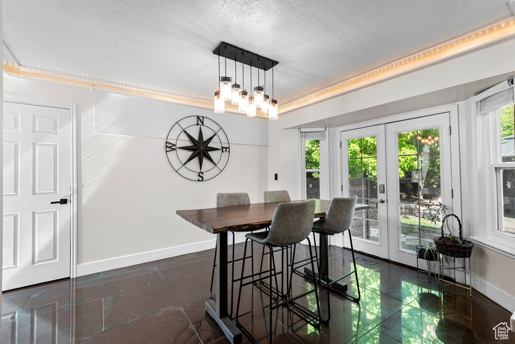 Dining area with french doors, baseboards, and a textured ceiling