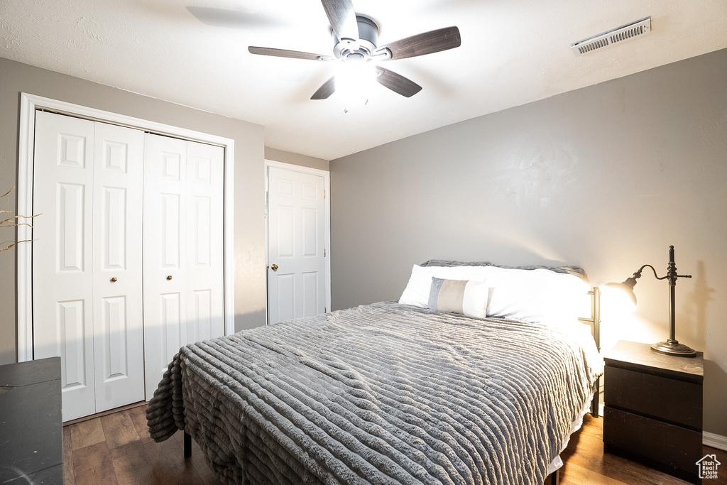 Bedroom featuring ceiling fan, visible vents, wood finished floors, and a closet