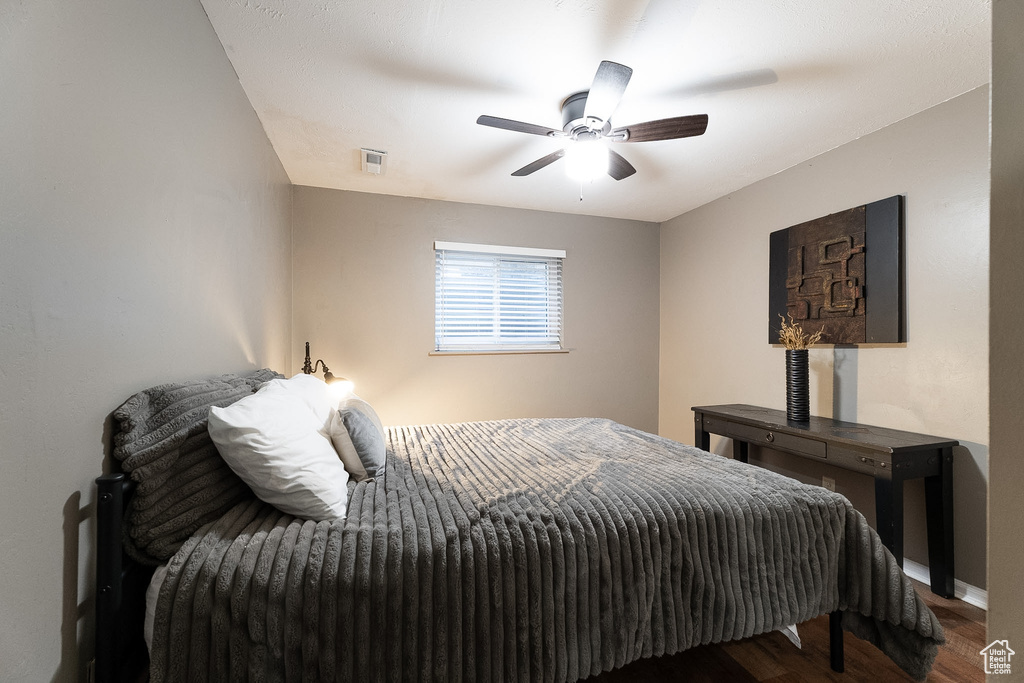 Bedroom featuring baseboards, ceiling fan, wood finished floors, and visible vents