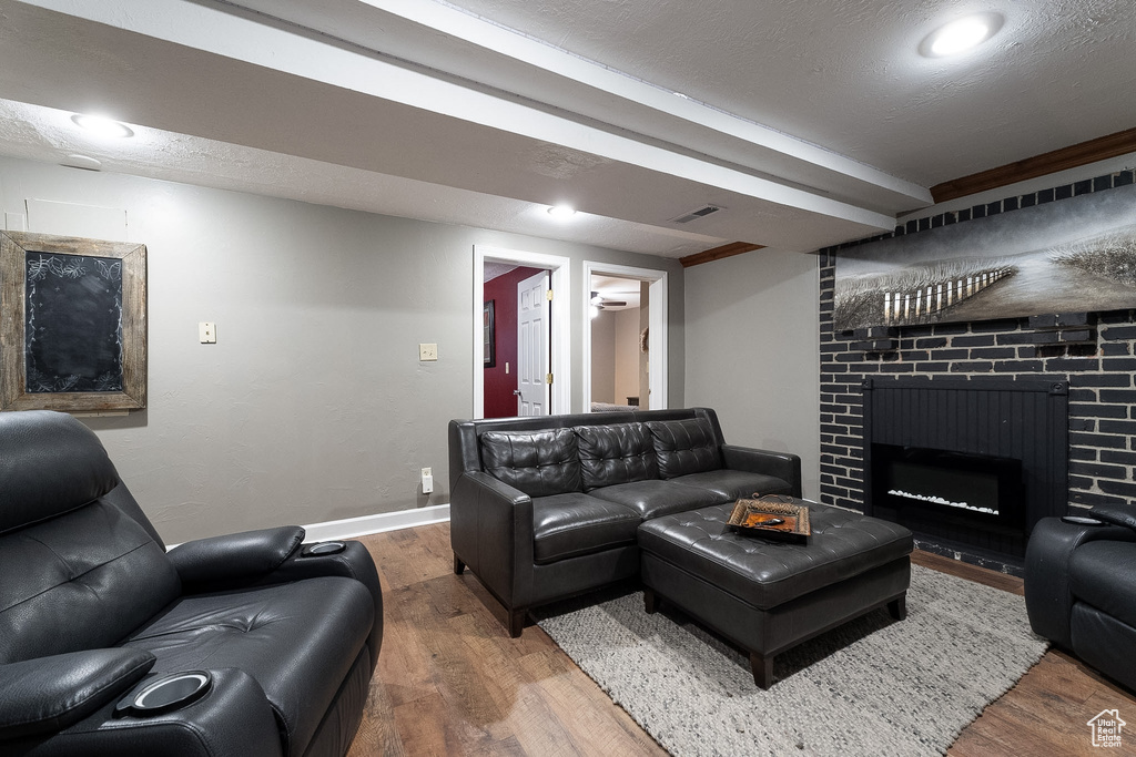 Living room featuring visible vents, baseboards, wood finished floors, and a fireplace