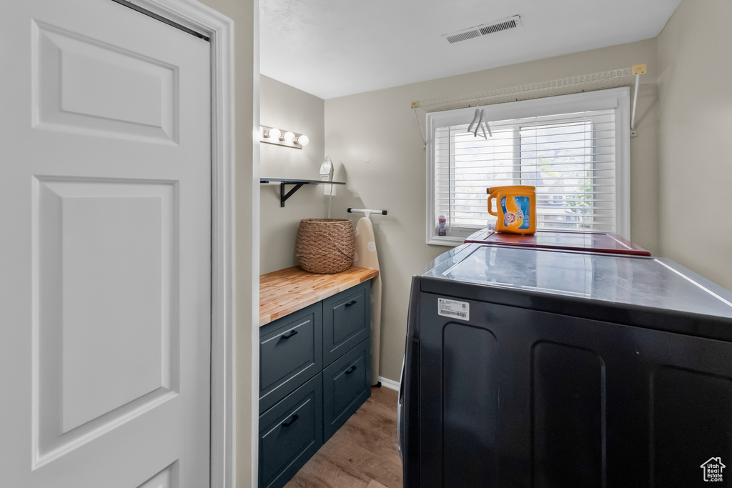 Laundry area with washer / dryer, laundry area, light wood-type flooring, and visible vents