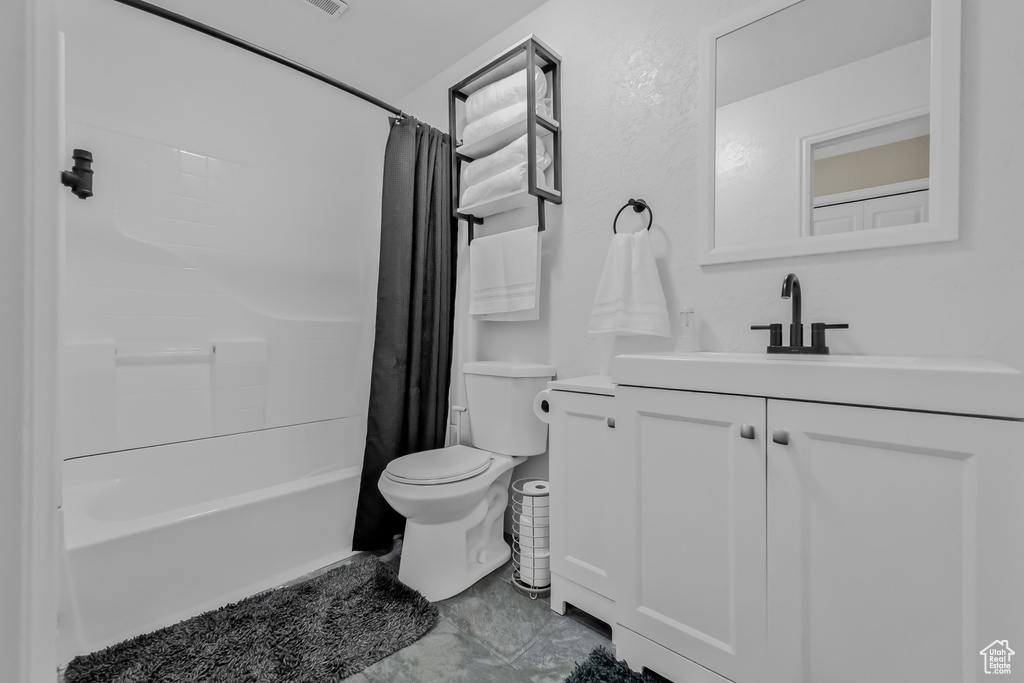 Full bathroom featuring vanity, shower / tub combo, and toilet