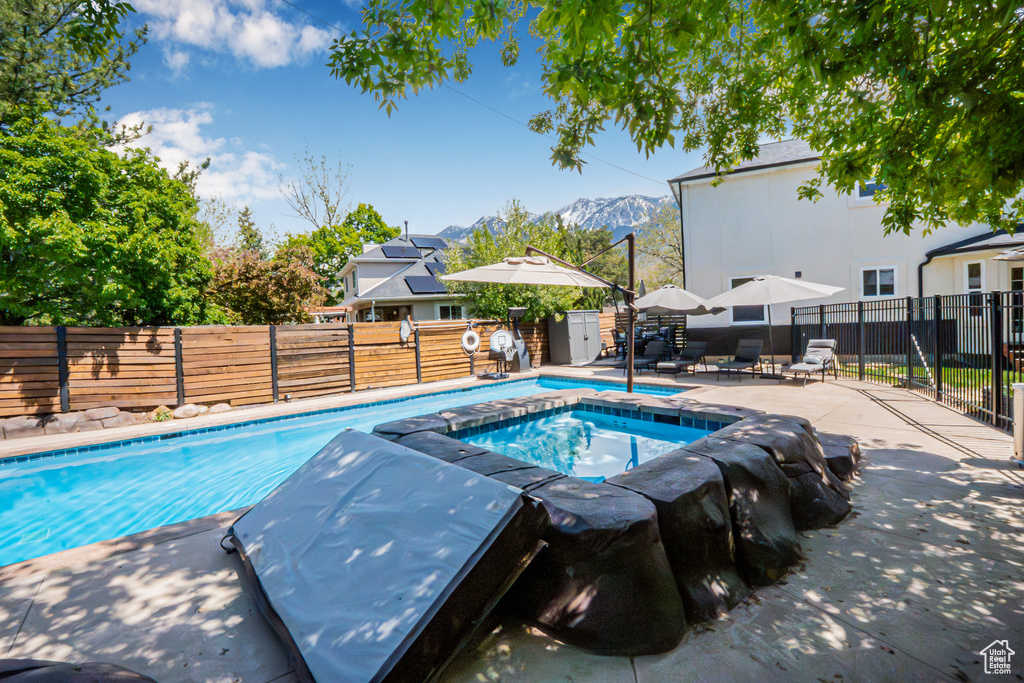 View of pool featuring a fenced backyard, a fenced in pool, and an in ground hot tub