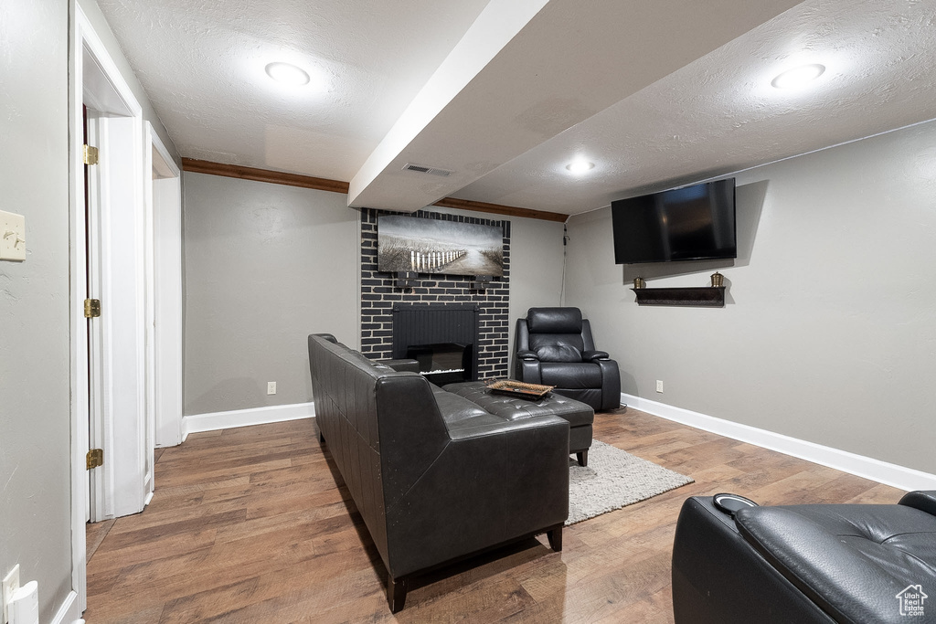 Living room featuring visible vents, baseboards, wood finished floors, and a fireplace