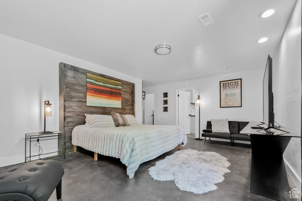 Bedroom featuring finished concrete flooring, recessed lighting, and visible vents