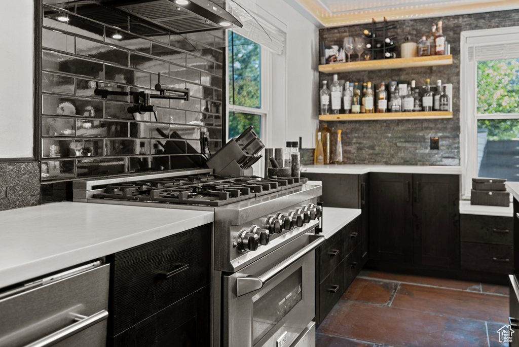 Indoor dry bar featuring high end stove and tasteful backsplash