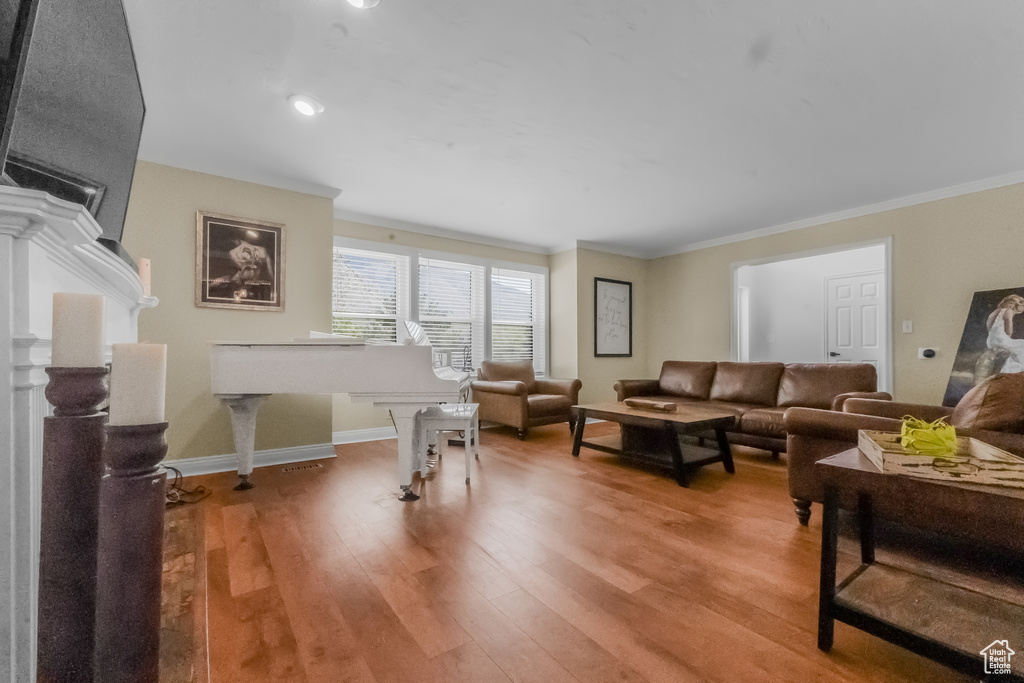 Living area featuring crown molding, light wood finished floors, and baseboards