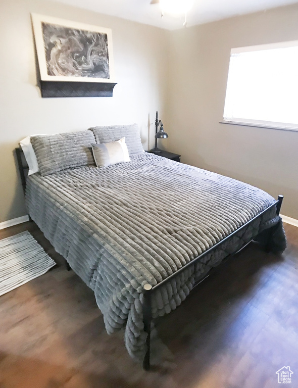 Bedroom with baseboards and wood finished floors
