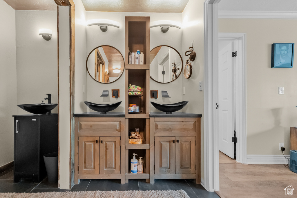 Bar with a sink, baseboards, and crown molding