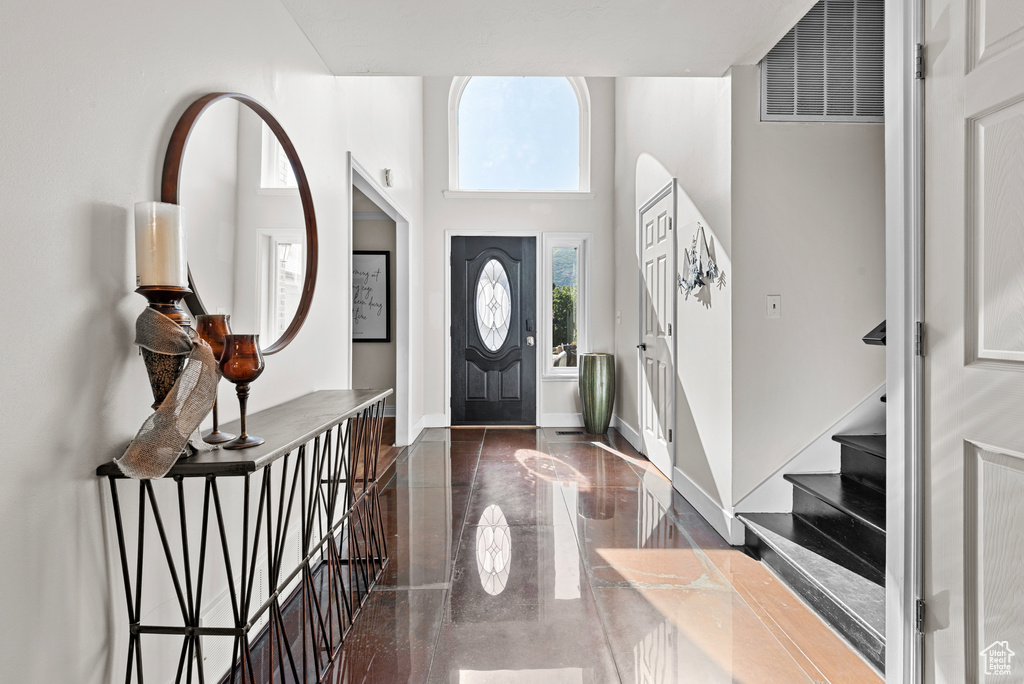 Foyer with a towering ceiling, stairway, and baseboards
