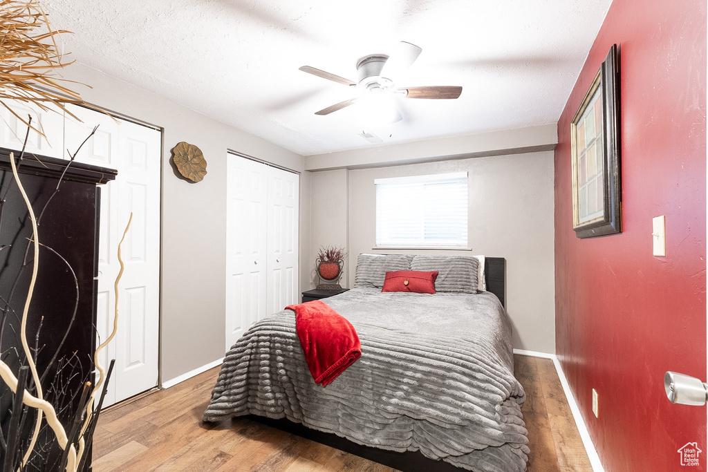 Bedroom with a ceiling fan, baseboards, and wood finished floors