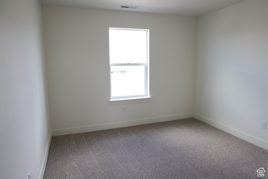 Unfurnished room with visible vents, carpet flooring, and baseboards