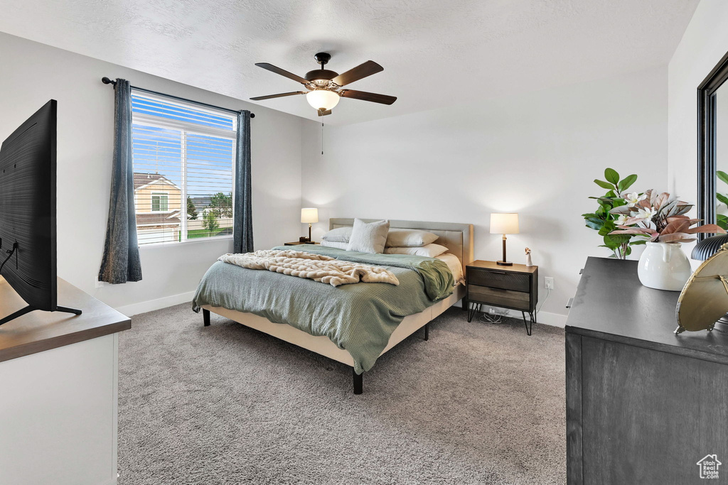 Carpeted bedroom featuring baseboards and ceiling fan