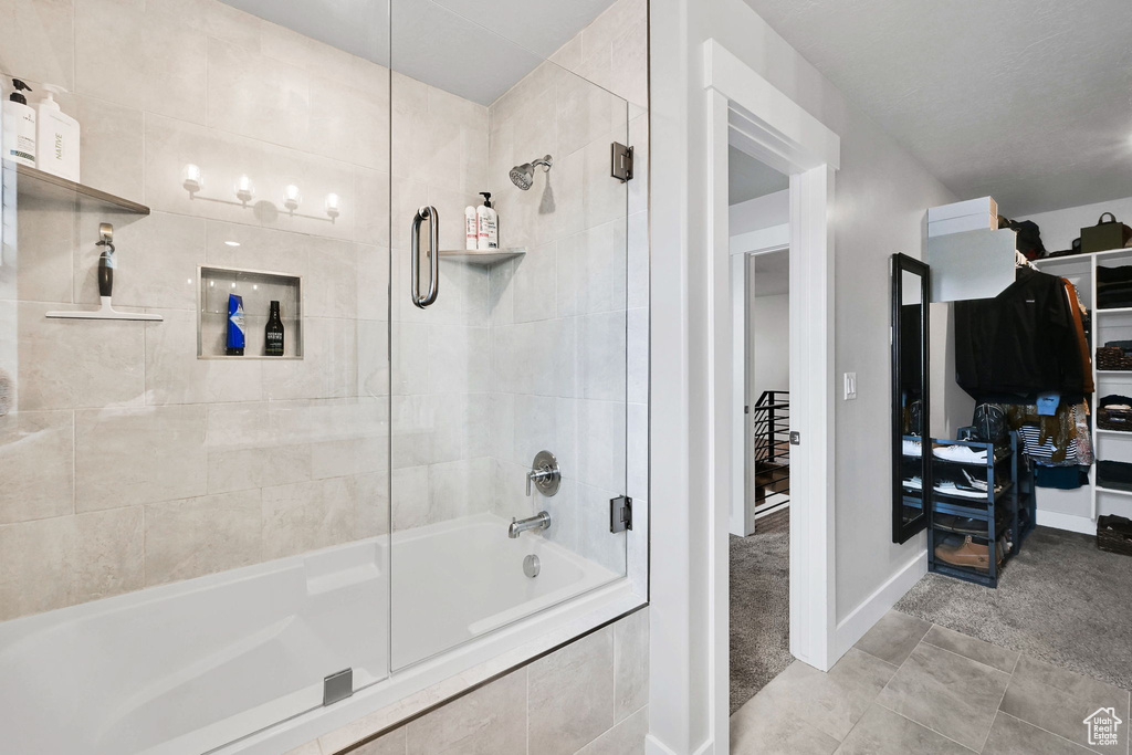 Bathroom featuring baseboards, tile patterned flooring, and tiled shower / bath combo