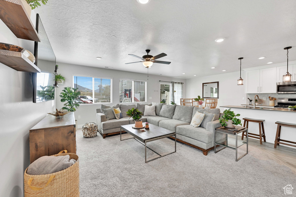 Living area with recessed lighting, ceiling fan, a healthy amount of sunlight, and a textured ceiling