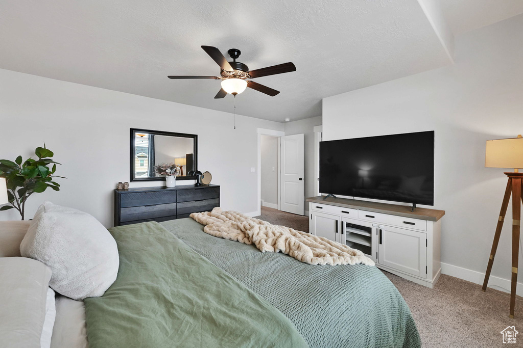 Bedroom with baseboards, ceiling fan, and light carpet