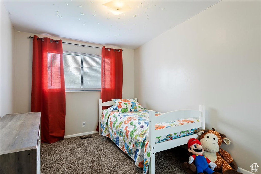 Carpeted bedroom with baseboards and visible vents