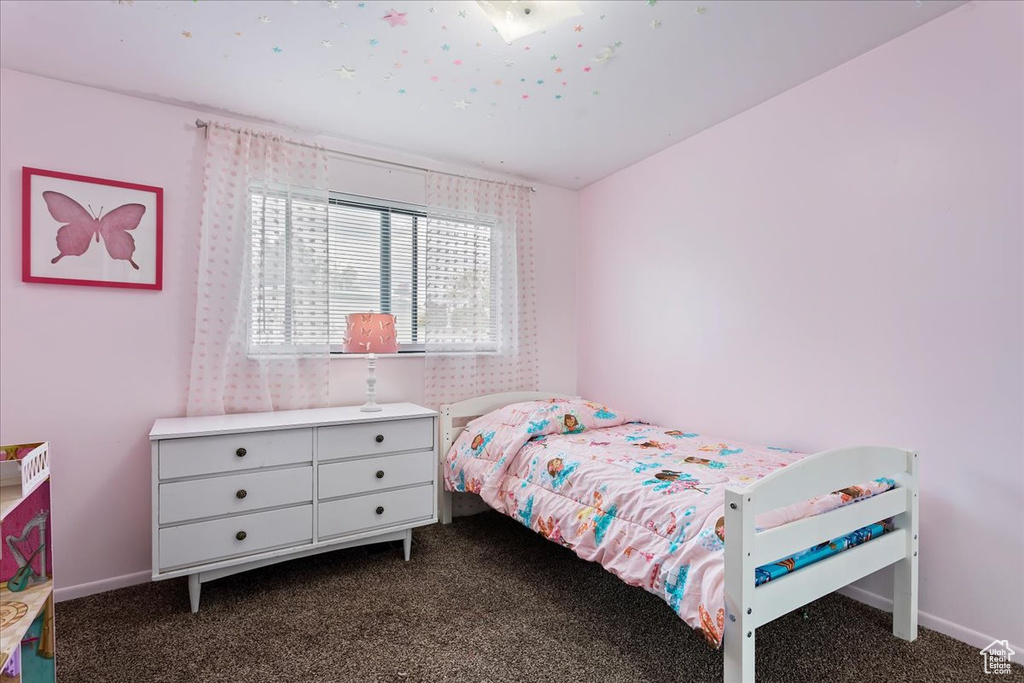 Bedroom featuring baseboards and dark colored carpet