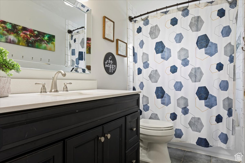 Full bathroom with vanity, a shower with shower curtain, tile patterned flooring, and toilet