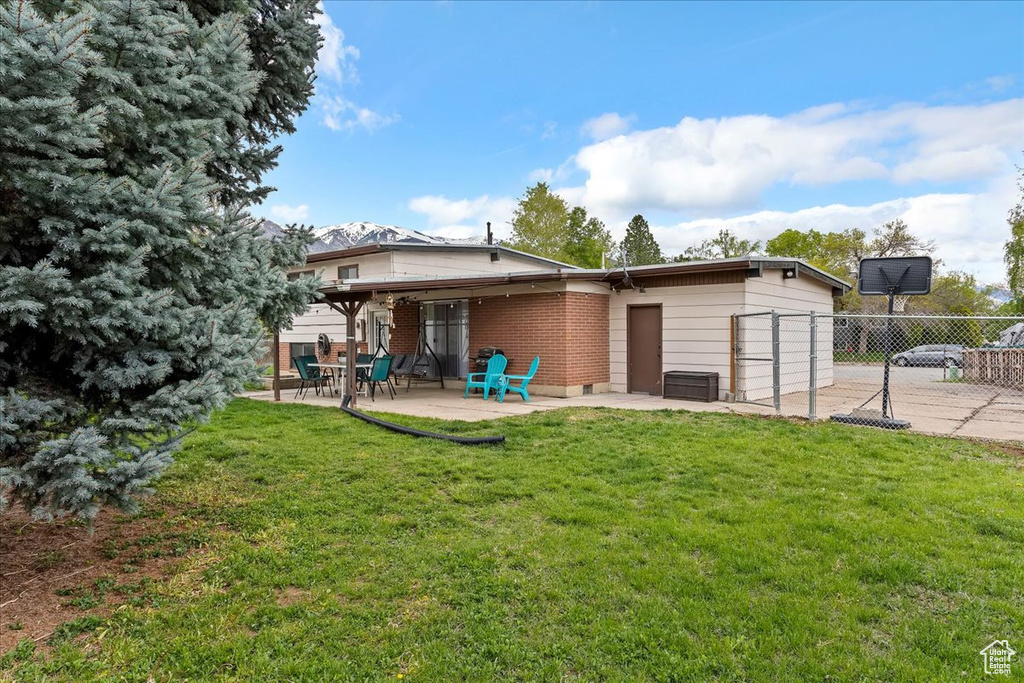 Back of house featuring a yard, a patio, and fence