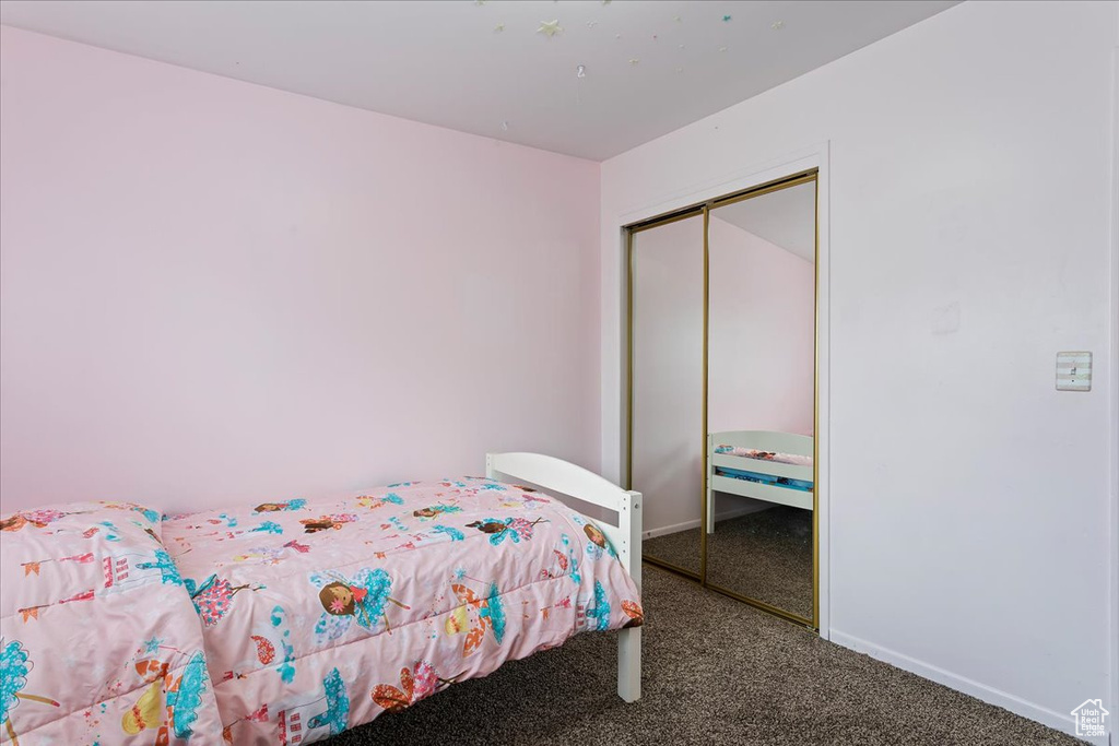 Bedroom with carpet floors, baseboards, and a closet