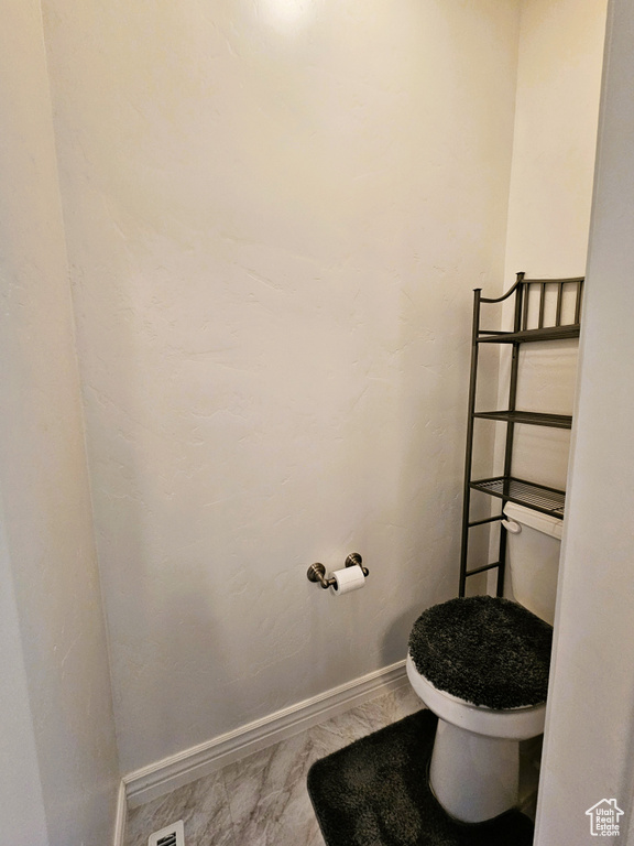 Bathroom featuring baseboards and toilet