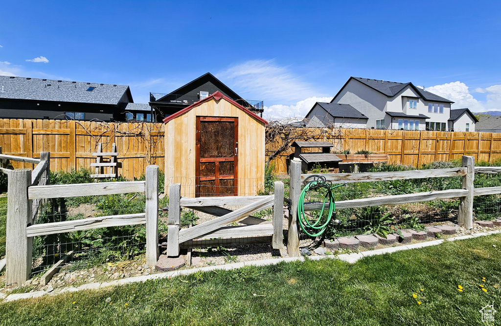 Exterior space with a fenced backyard, an outdoor structure, and a storage shed