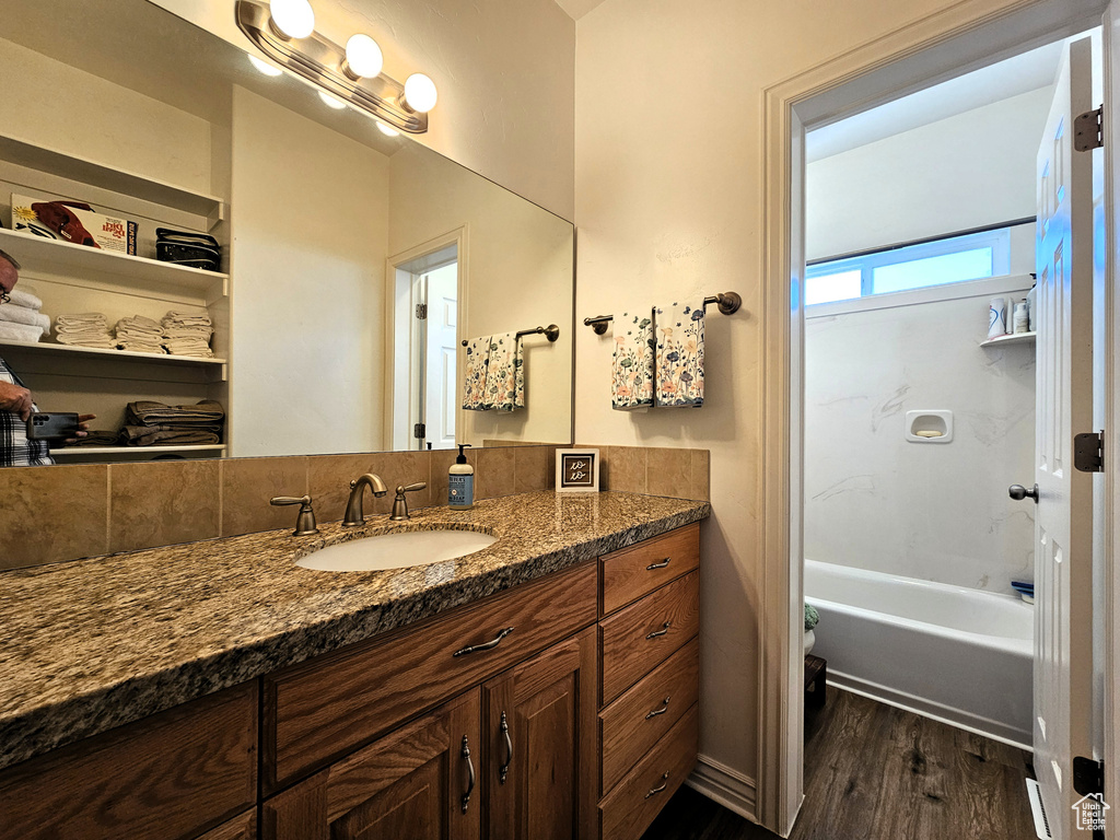 Full bath with shower / bath combination, wood finished floors, and vanity