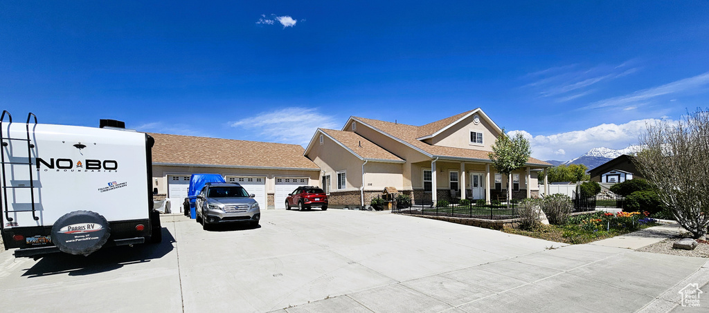 View of front of home with an attached garage, stucco siding, and driveway