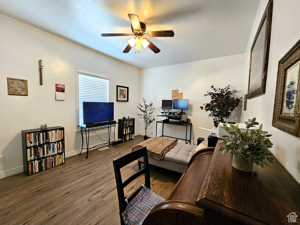 Living room featuring baseboards, a ceiling fan, and wood finished floors