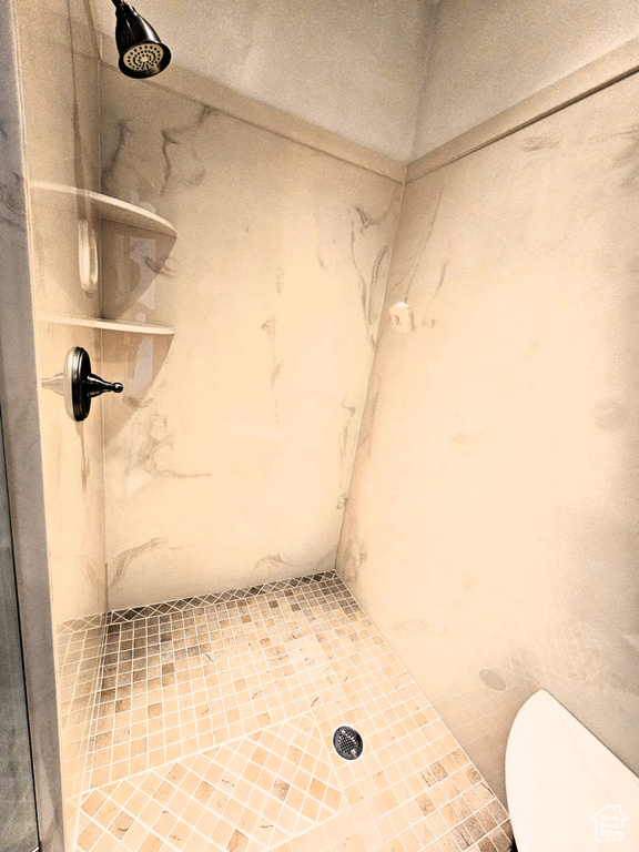 Bathroom with a marble finish shower and toilet