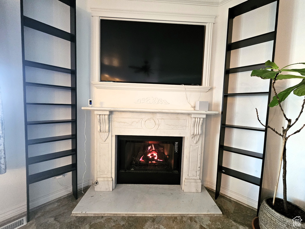 Interior details featuring baseboards, visible vents, built in features, and a high end fireplace