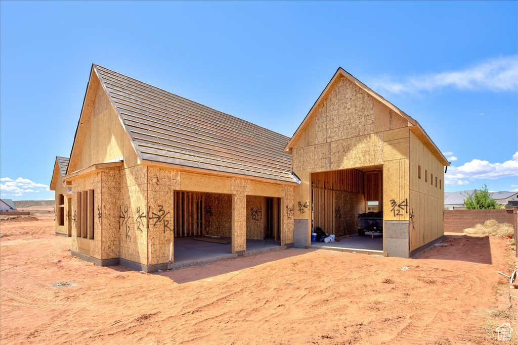 Rear view of property featuring fence and a detached garage