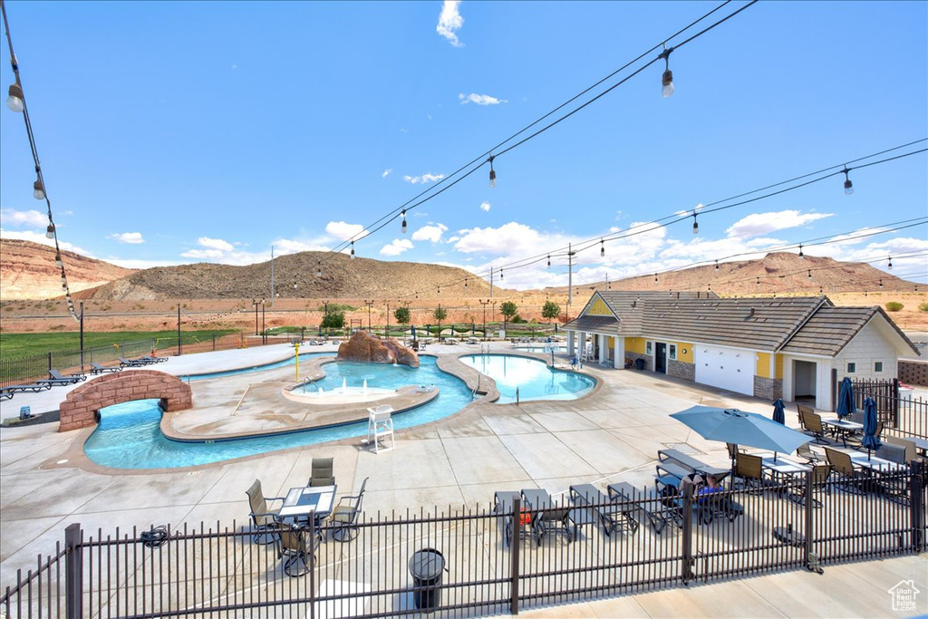 Pool featuring fence, a mountain view, a jacuzzi, and a patio