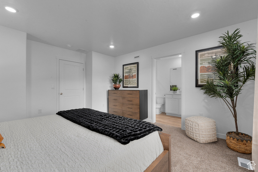 Bedroom with recessed lighting, connected bathroom, visible vents, and light colored carpet